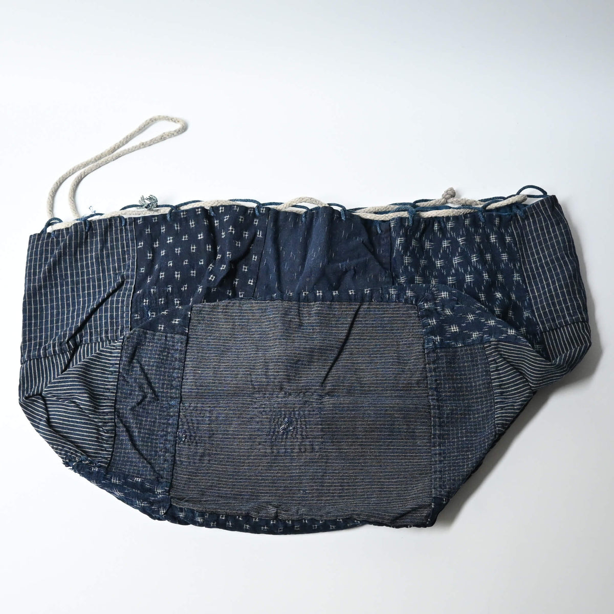 A rare vintage Japanese komebukuro, a traditional drawstring cotton rice bag hand pieced from a variety of indigo cottons.