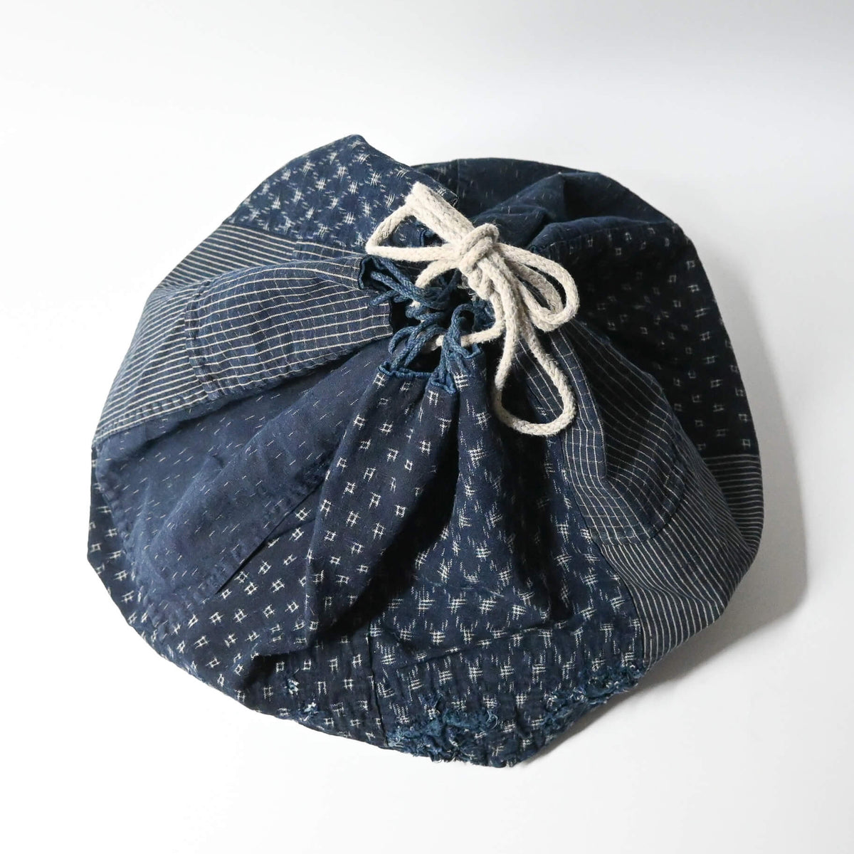 A rare vintage Japanese komebukuro, a traditional drawstring cotton rice bag hand pieced from a variety of indigo cottons.