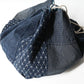 Close-up view of a rare vintage Japanese komebukuro, a traditional drawstring cotton rice bag hand pieced from a variety of indigo cottons.