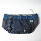 Inside of a rare vintage Japanese komebukuro, a traditional drawstring cotton rice bag hand pieced from a variety of indigo cottons with mended patches.