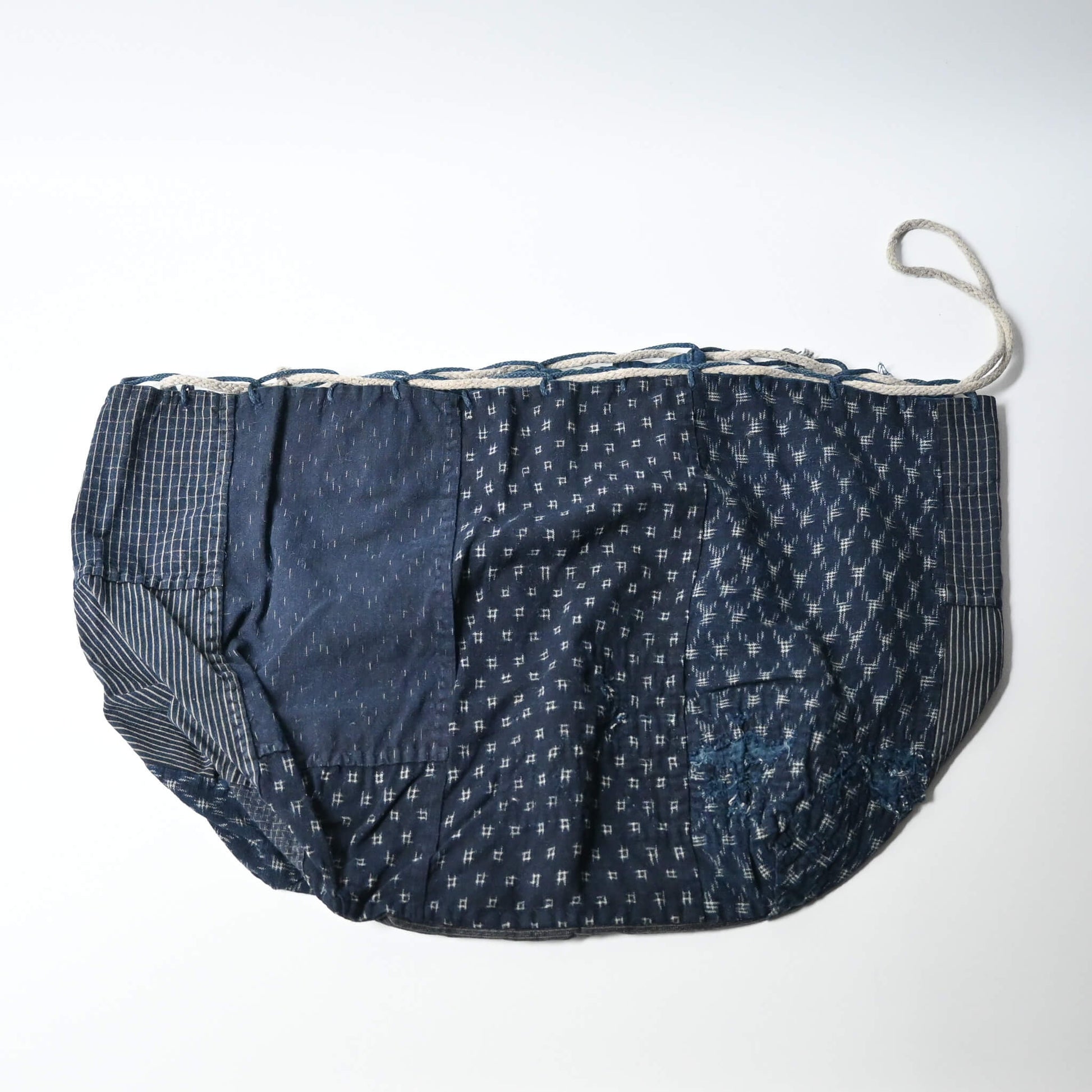 A rare vintage Japanese komebukuro, a traditional drawstring cotton rice bag hand pieced from a variety of indigo cottons.