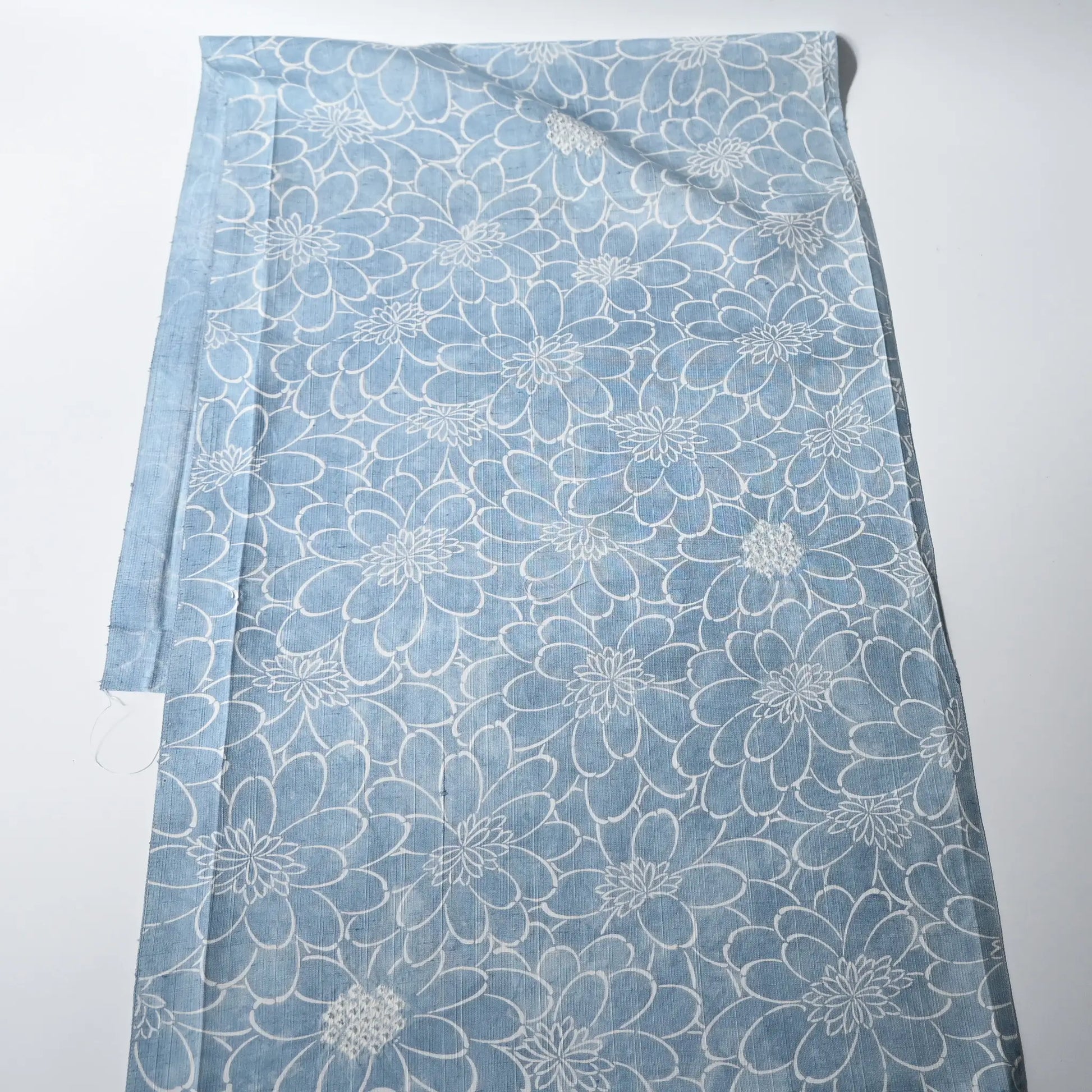 Vintage light blue tsumugi silk kimono fabric with chrysanthemum motifs and shibori accents.