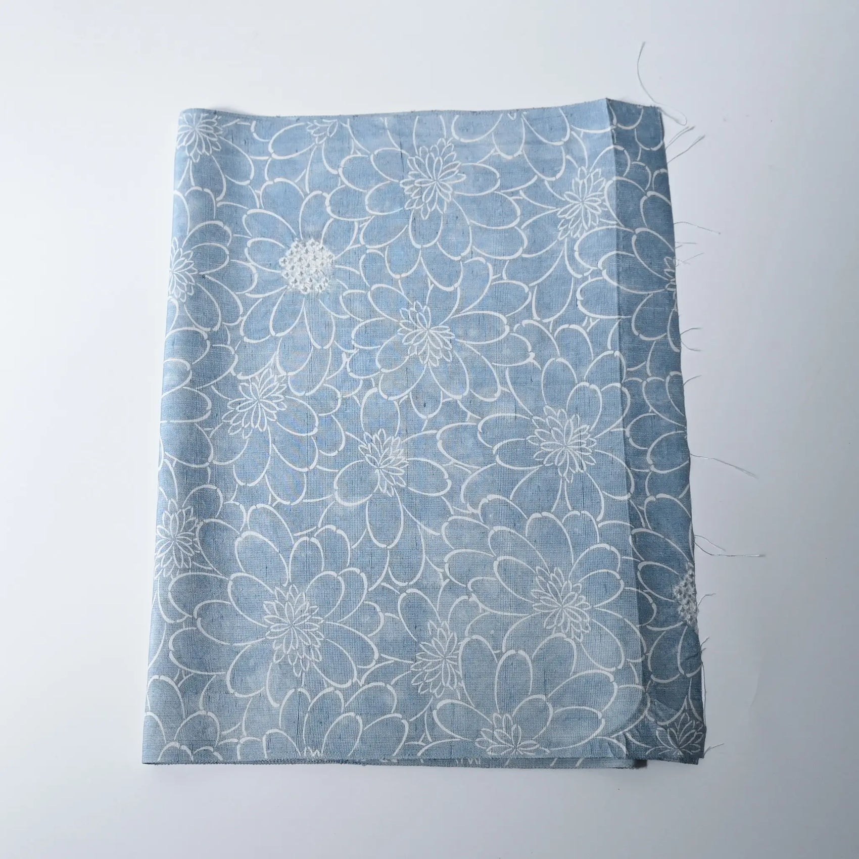 Vintage light blue tsumugi silk kimono fabric with chrysanthemum motifs and shibori accents.