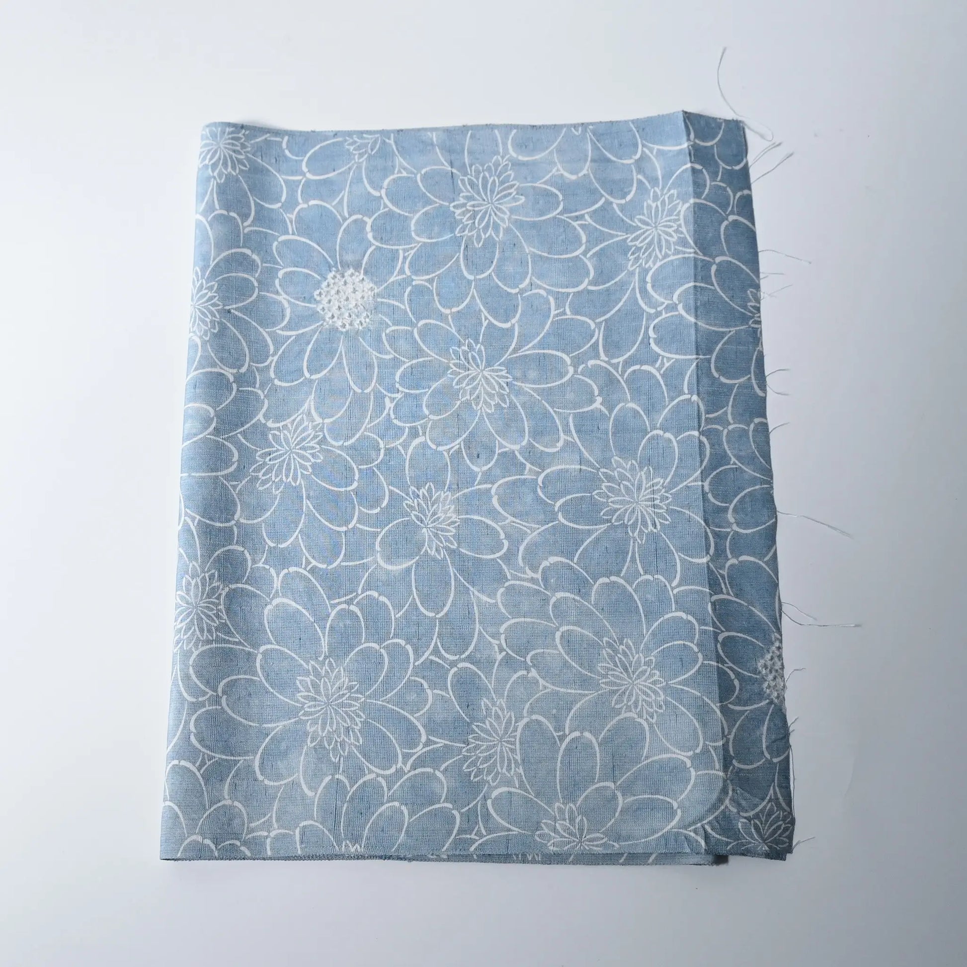Vintage light blue tsumugi silk kimono fabric with chrysanthemum motifs and shibori accents.