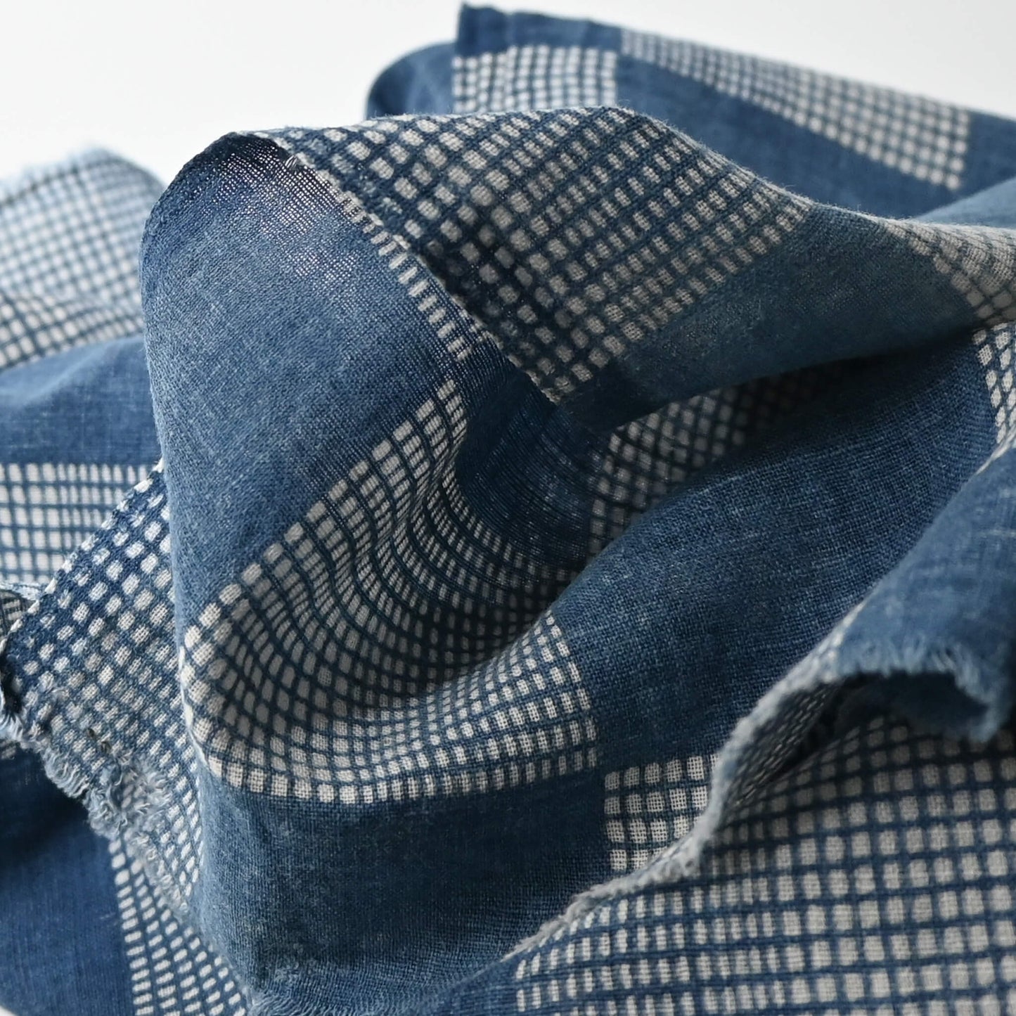 Close-up view of vintage lightweight soft indigo cotton piece from an old kimono with a large chequered design.