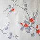 Detailed view of vintage Japanese tsumugi silk kimono fabric piece in light grey with charming plum blossom design.