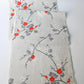 Full view of vintage Japanese tsumugi silk kimono fabric piece in light grey with charming plum blossom design.