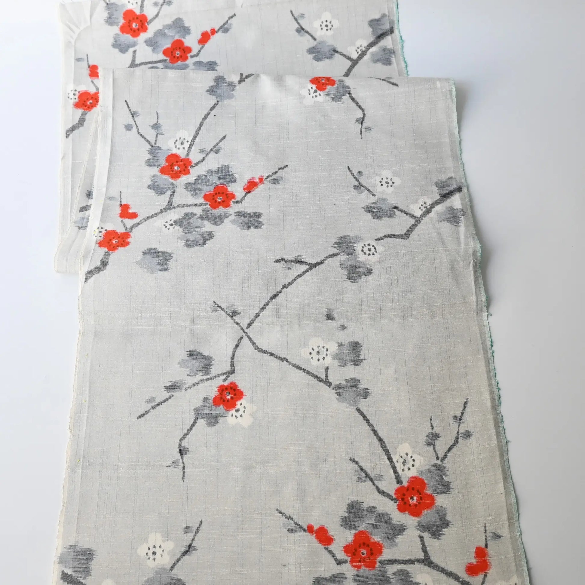 Full view of vintage Japanese tsumugi silk kimono fabric piece in light grey with charming plum blossom design.
