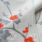 Detailed view of vintage Japanese tsumugi silk kimono fabric piece in light grey with charming plum blossom design.