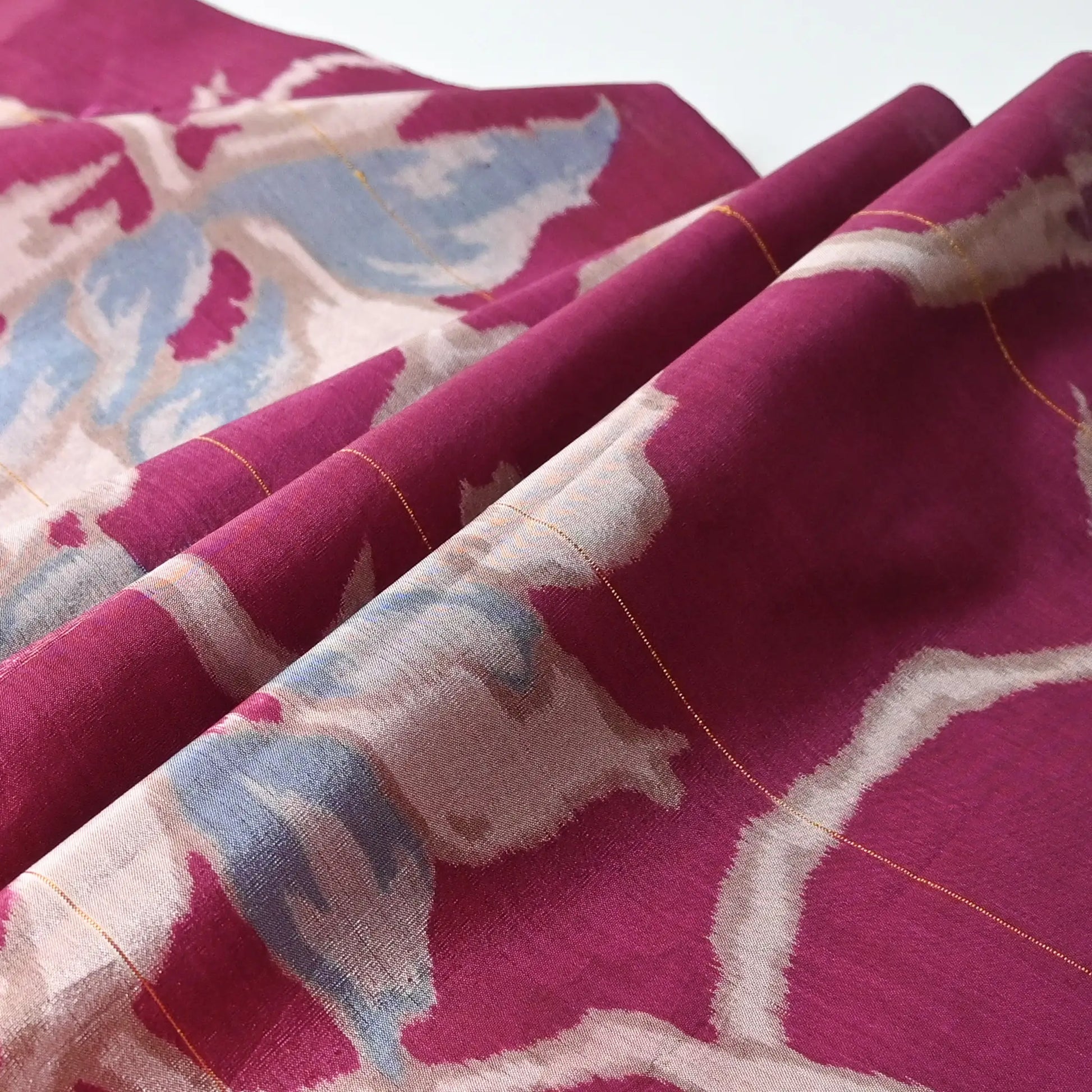 Detailed view of vintage Meisen kimono silk fabric, magenta colour with light blue floral pattern from the mid-20th century.