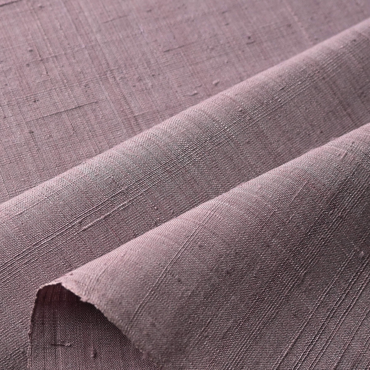 Close-up view of vintage Japanese slub textured tsumugi silk kimono fabric piece in dusty mauve tone.