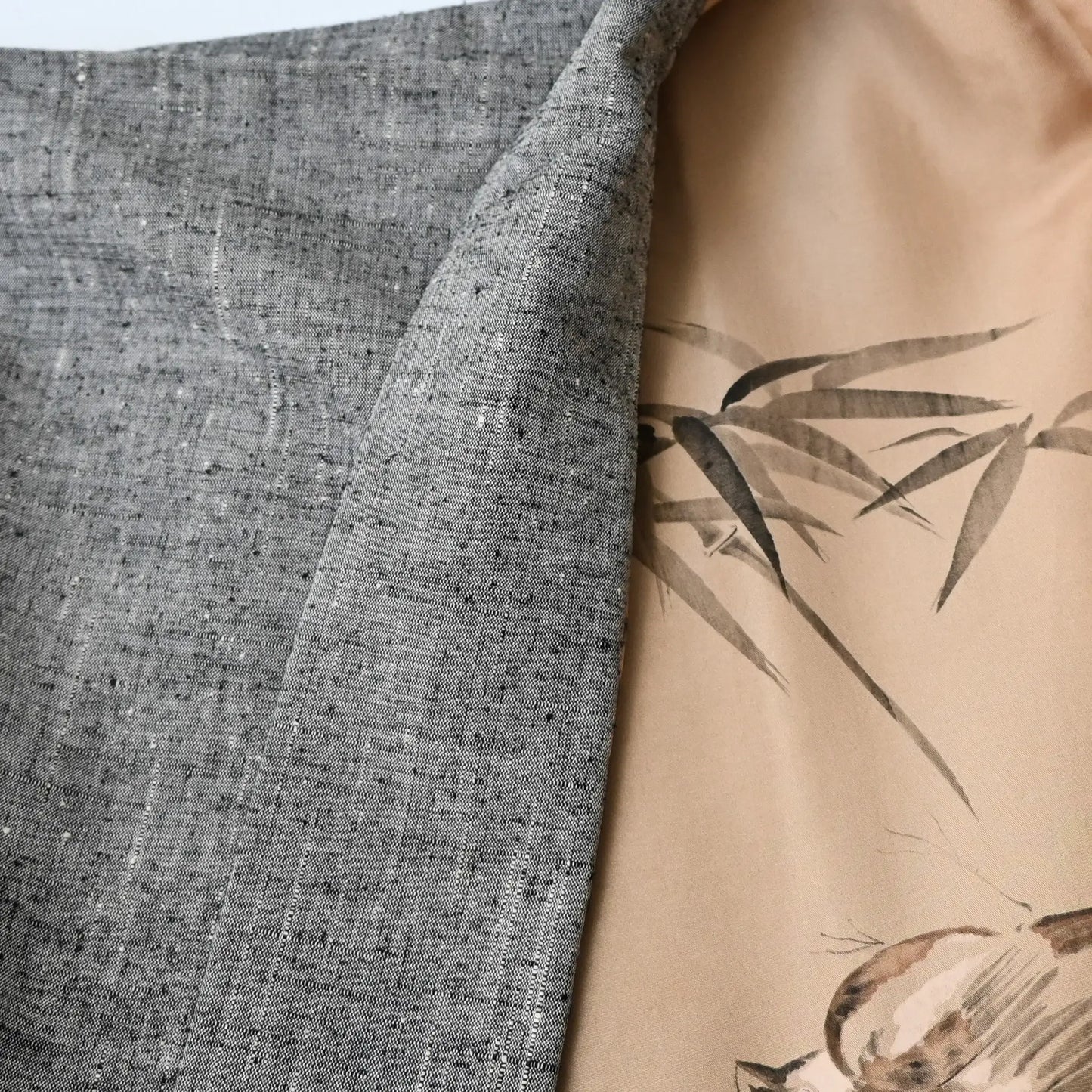 Detailed view of vintage men's grey tsumugi silk haori with hand-painted lining.