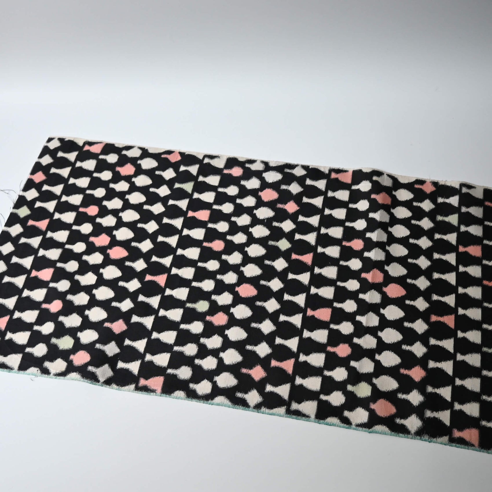 Full view of vintage Meisen silk kimono fabric piece, stylised vase motif in white and pink against black.