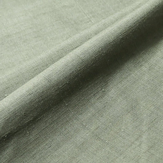 Close-up view of vintage plain tsumugi silk, men's kimono bolt in moss green, sold by the metre.