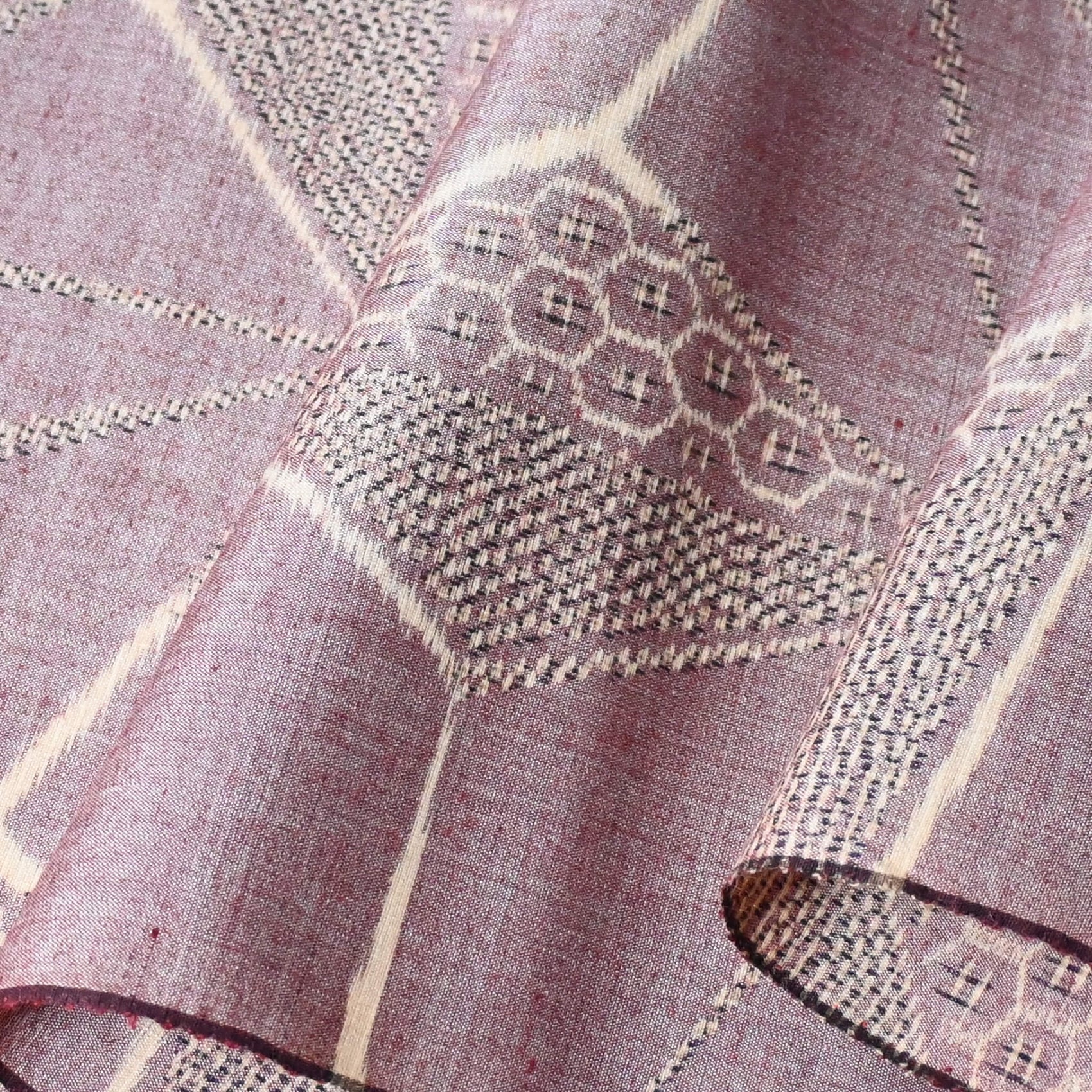 Close-up view of vintage tsumugi silk kimono fabric in muted mauve tone with a large-scale asanoha motif.