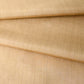 Close-up view of vintage tsumugi silk kimono fabric piece in a warm, muted yellow tone, gentle sheen.