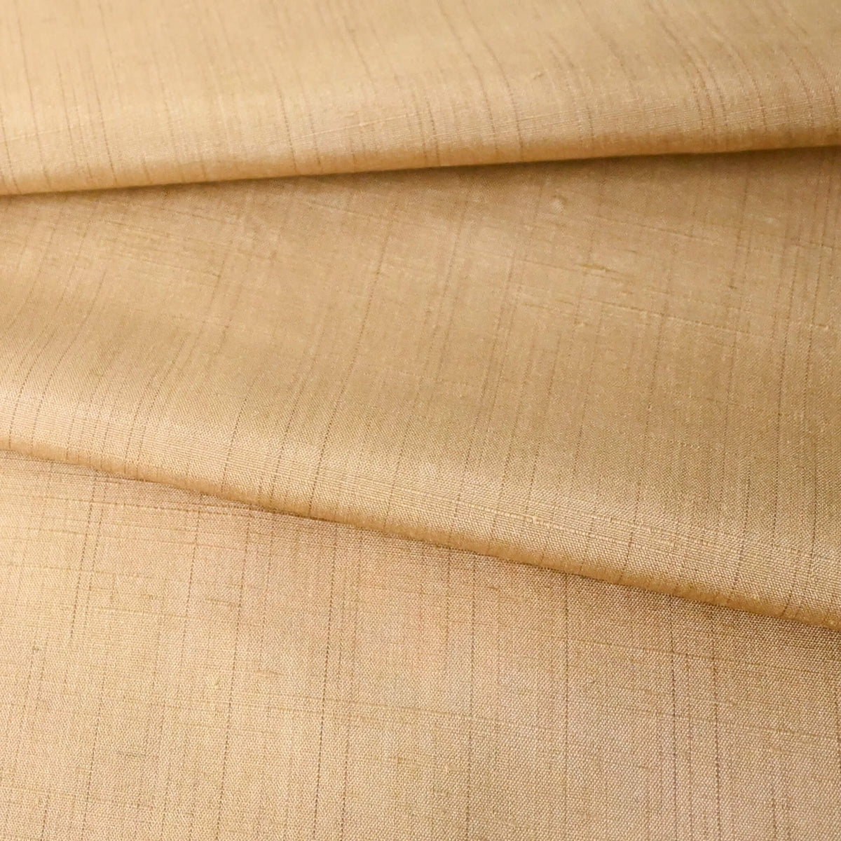 Close-up view of vintage tsumugi silk kimono fabric piece in a warm, muted yellow tone, gentle sheen.