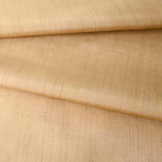 Close-up view of vintage tsumugi silk kimono fabric piece in a warm, muted yellow tone, gentle sheen.