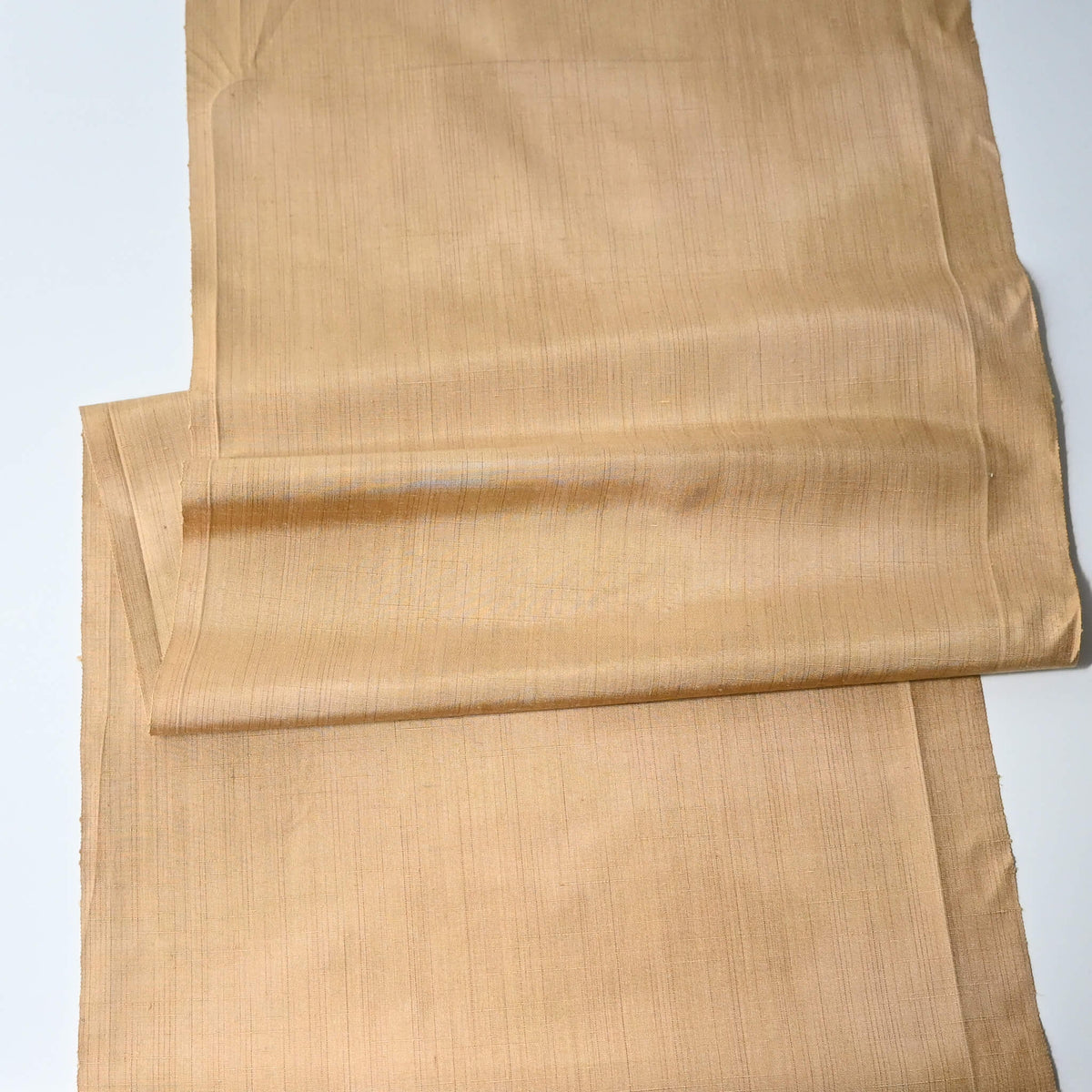 Full view of vintage tsumugi silk kimono fabric piece in a warm, muted yellow tone, gentle sheen.