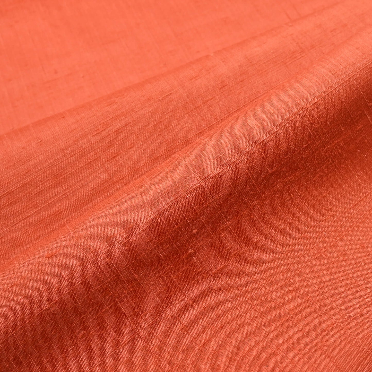 Close-up view of vintage hand-spun tsumugi silk kimono fabric naturally dyed with safflower, sold by the metre.