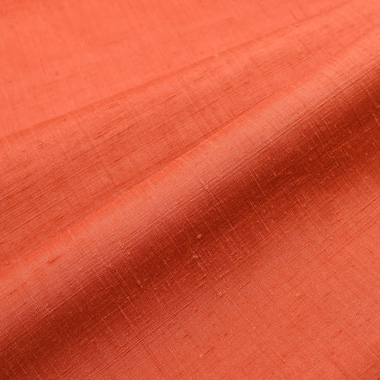 Close-up view of vintage hand-spun tsumugi silk kimono fabric naturally dyed with safflower, sold by the metre.