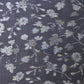 Close-up view of vintage tsumugi silk kimono fabric with silver grey vine floral pattern on a navy ground.