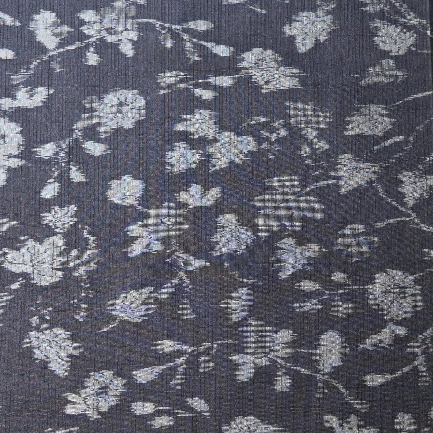 Close-up view of vintage tsumugi silk kimono fabric with silver grey vine floral pattern on a navy ground.