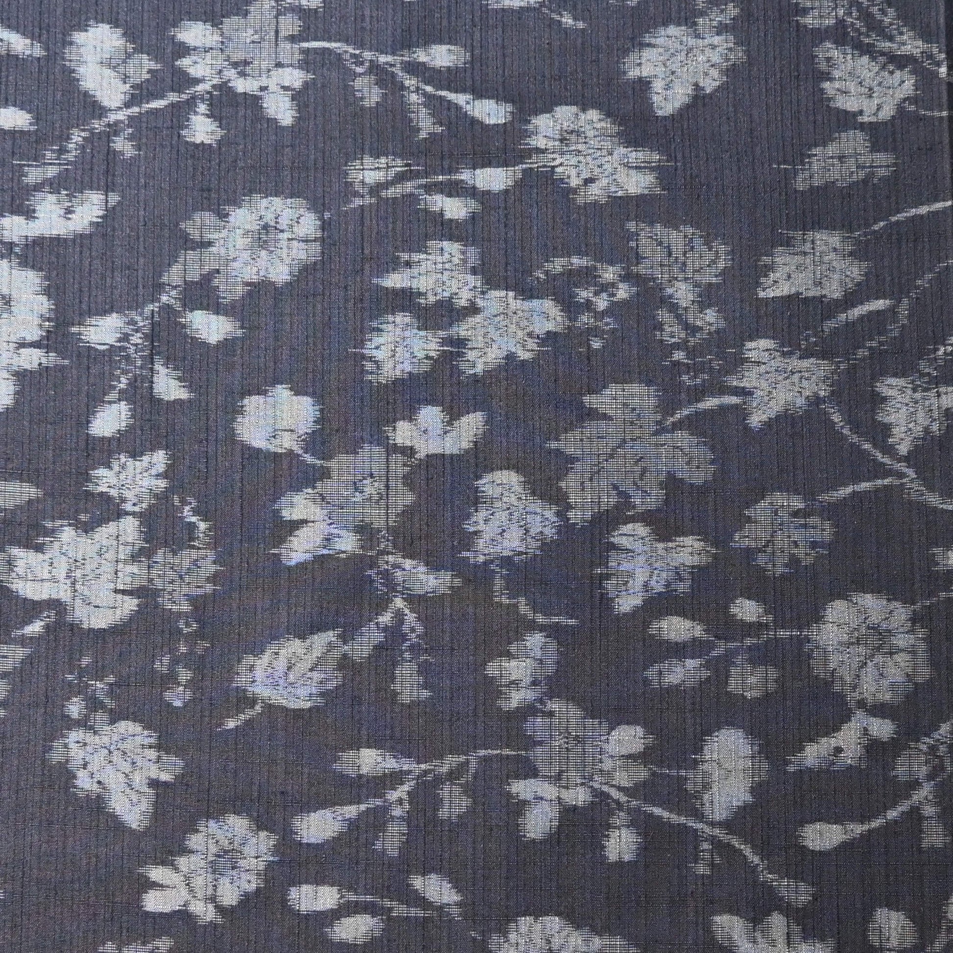 Close-up view of vintage tsumugi silk kimono fabric with silver grey vine floral pattern on a navy ground.