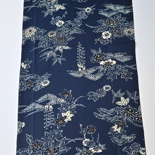 Full view of vintage Chirimen  silk crepe kimono fabric in navy with traditional Japanese seasonal flowers and trees.