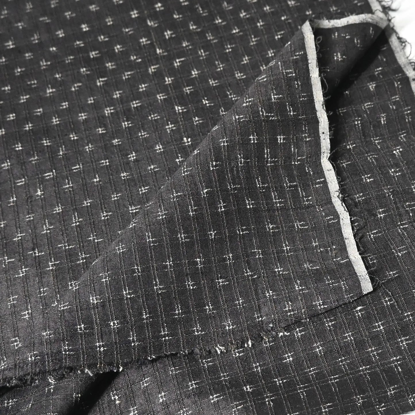 Detailed view of vintage silk kimono in dark navy with small kasuri woven pattern from the mid-20th century.