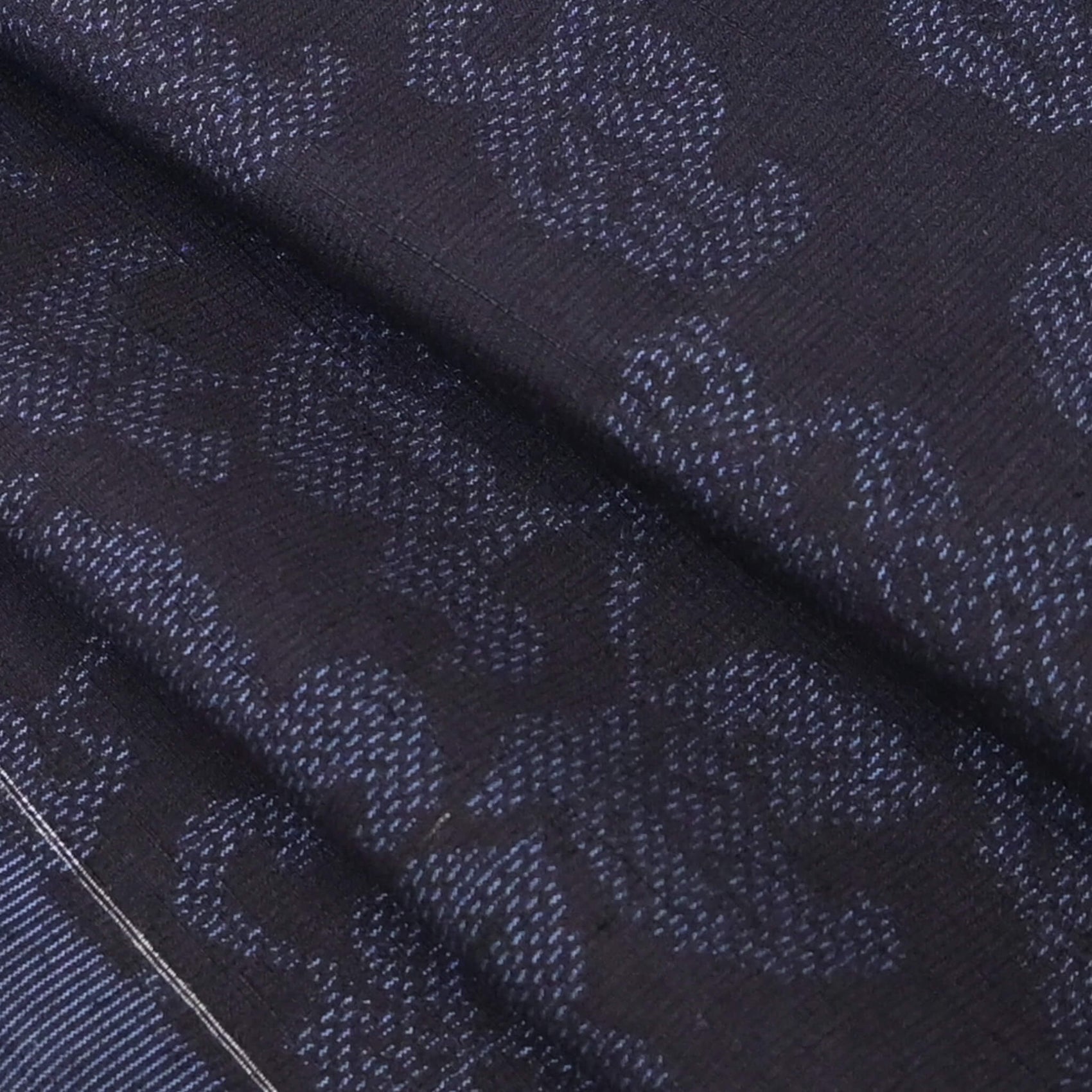 Close-up view of vintage navy tsumugi silk kimono fabric with peony foliage pattern, sold by the metre.