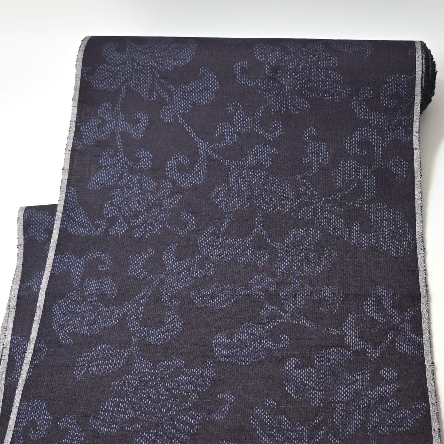 Full view of vintage navy tsumugi silk kimono fabric with peony foliage pattern, sold by the metre.