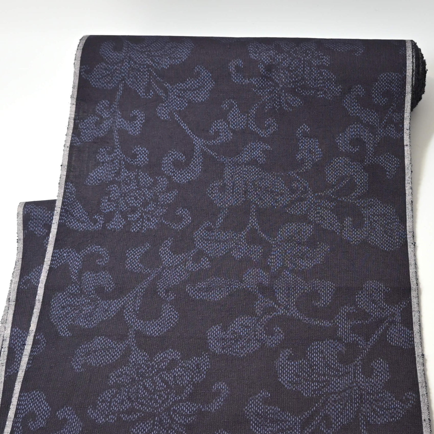 Full view of vintage navy tsumugi silk kimono fabric with peony foliage pattern, sold by the metre.