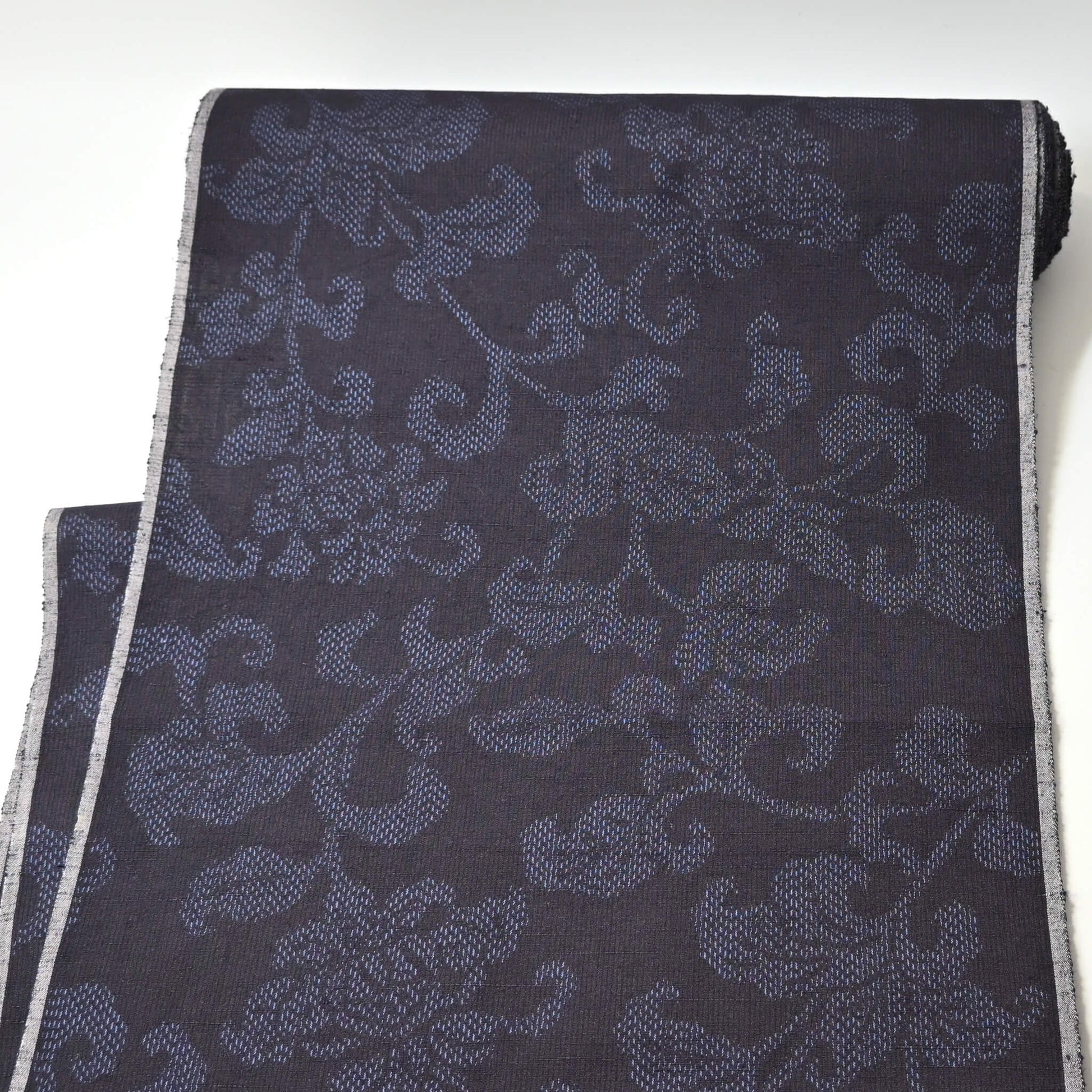 Full view of vintage navy tsumugi silk kimono fabric with peony foliage pattern, sold by the metre.