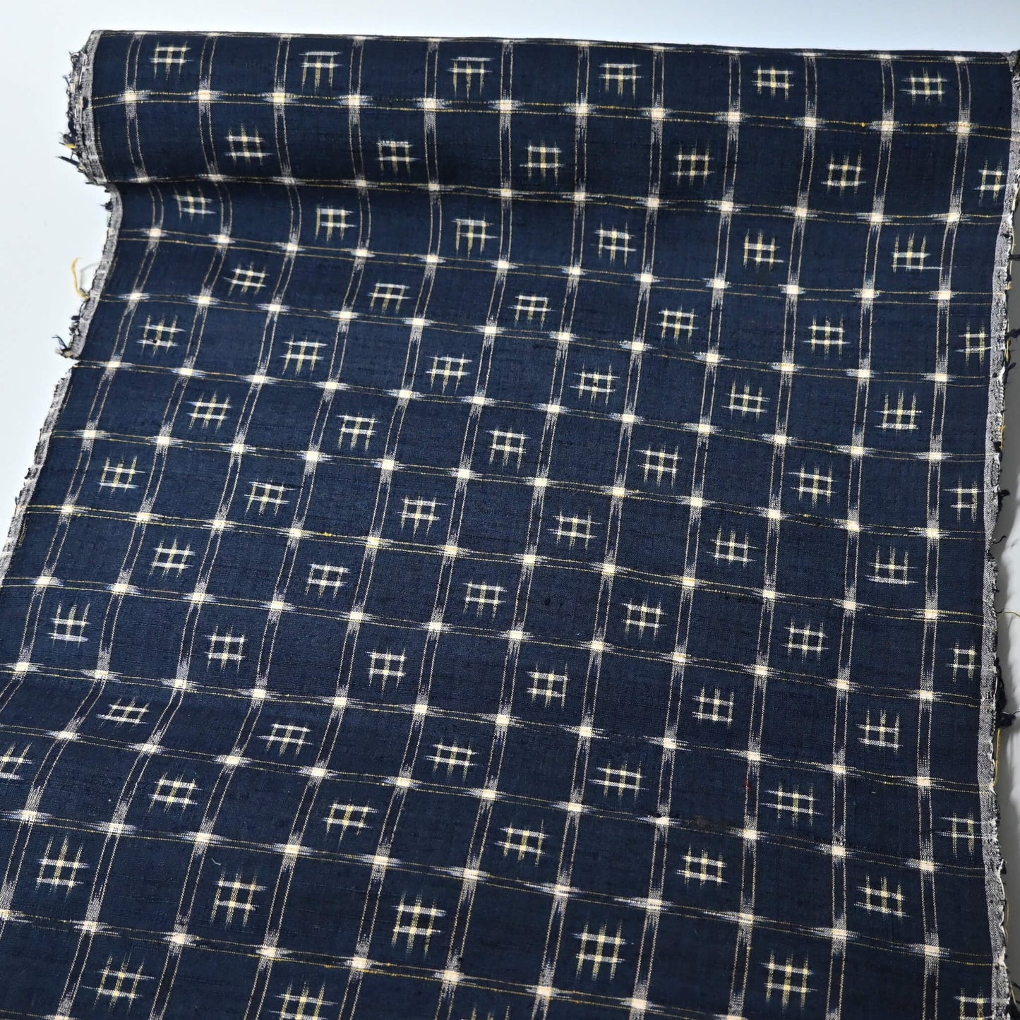 Full view of vintage navy tsumugi silk kimono fabric with woven kasuri pattern.