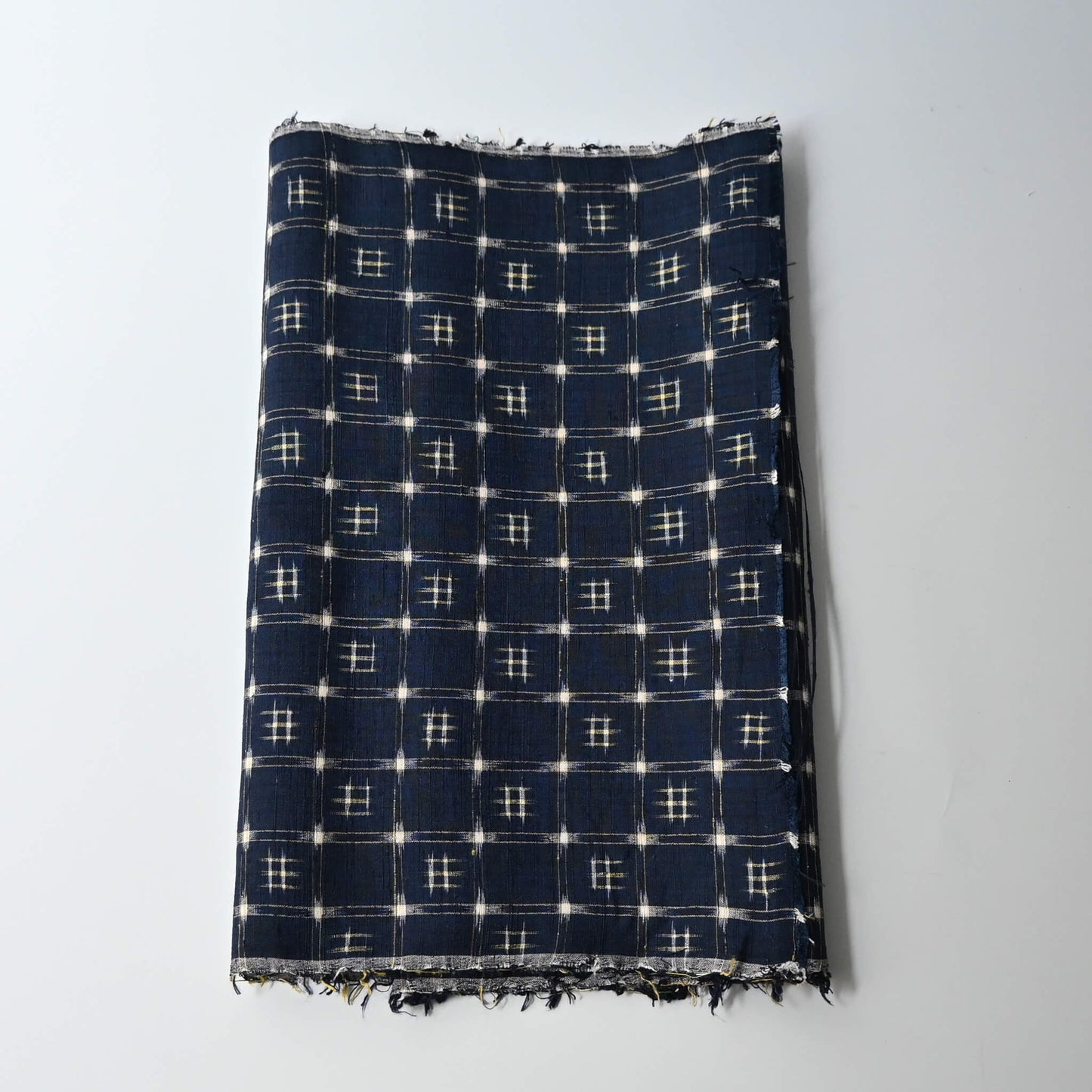 Vintage navy tsumugi silk kimono fabric with woven kasuri pattern.
