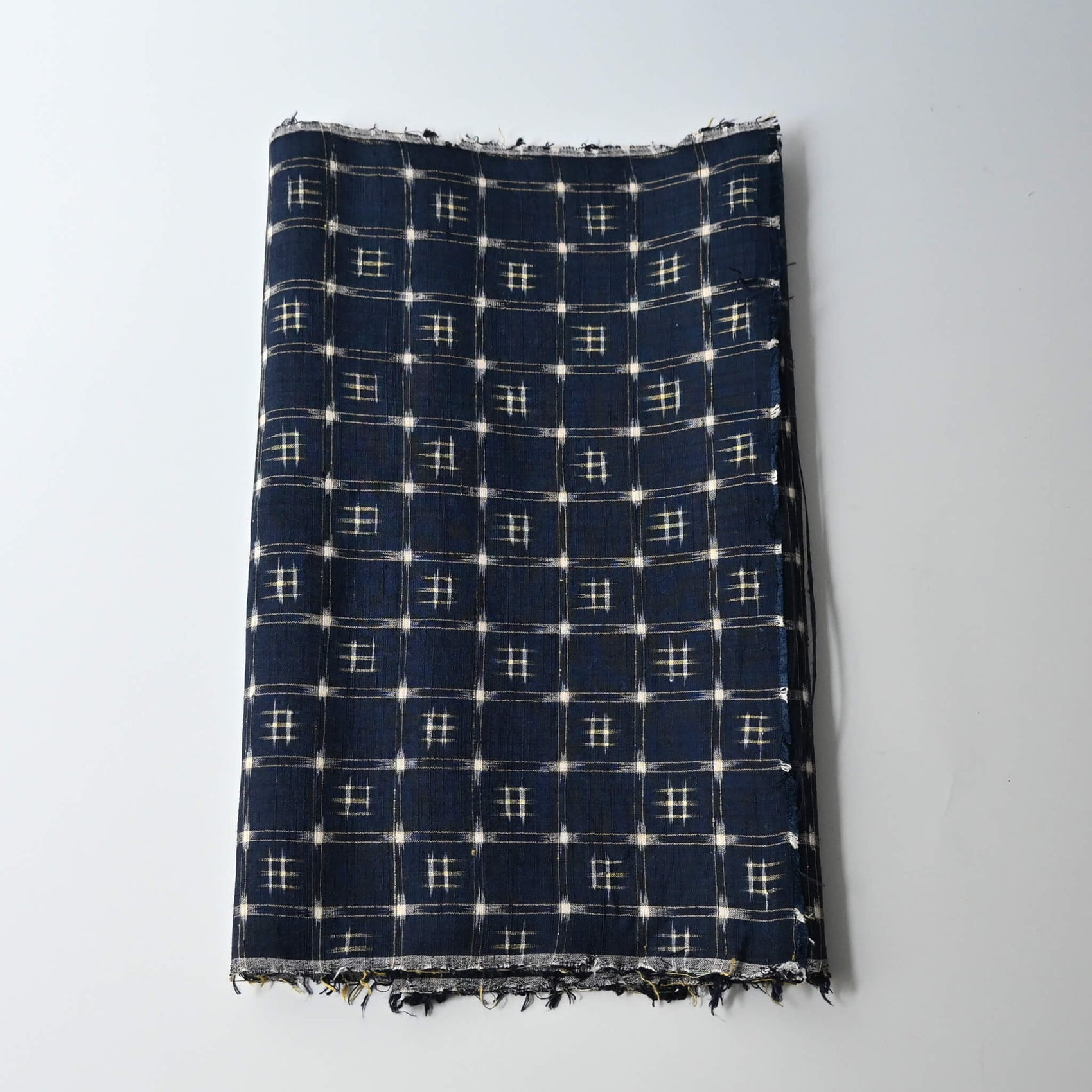 Vintage navy tsumugi silk kimono fabric with woven kasuri pattern.