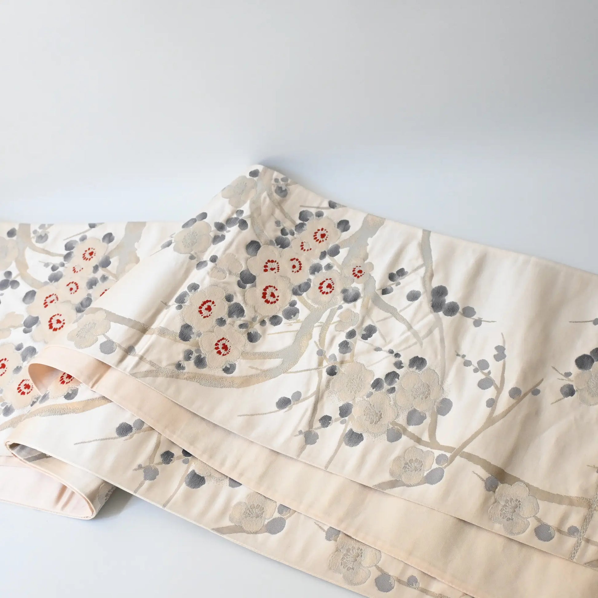 Full view of vintage women's off-white silk fukuro obi with elegant plum blossom motif.