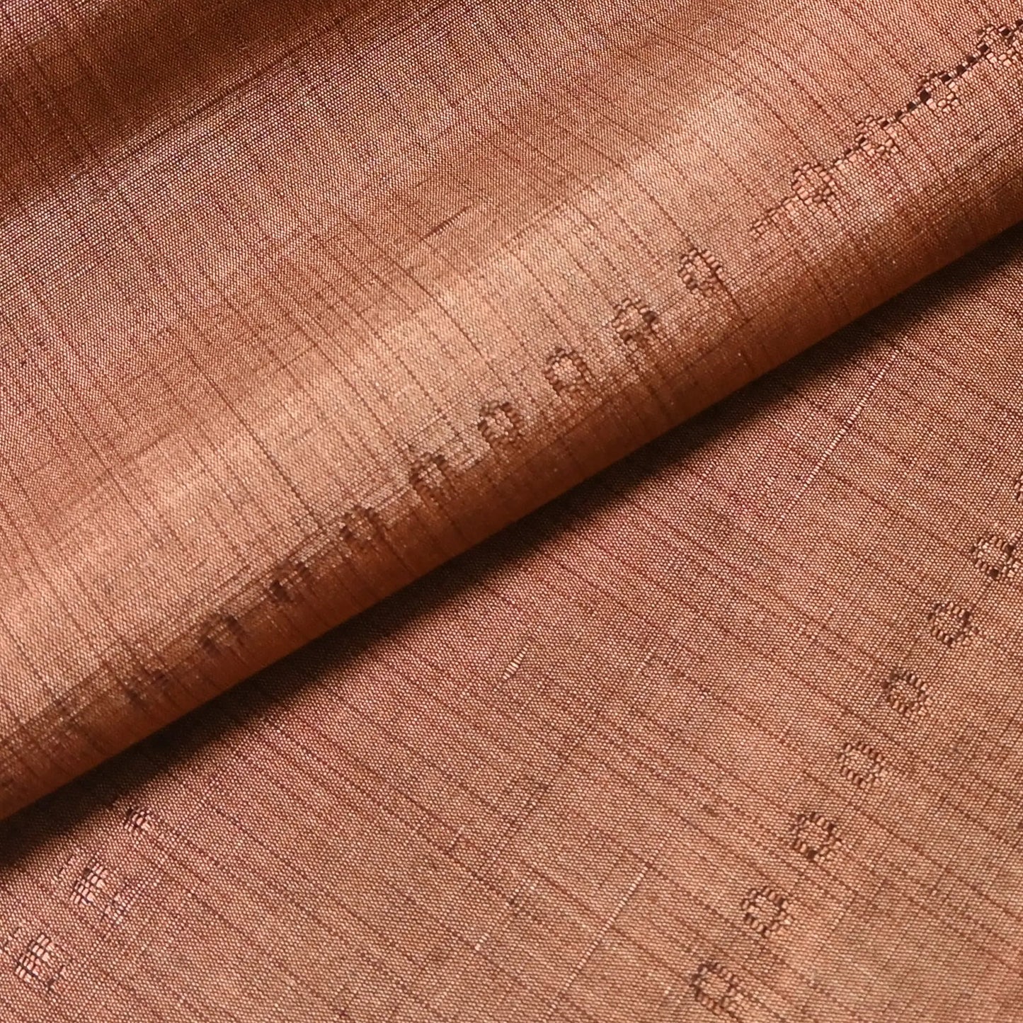 Detailed view of vintage pink brown tsumugi silk kimono fabric roll sold by the metre.