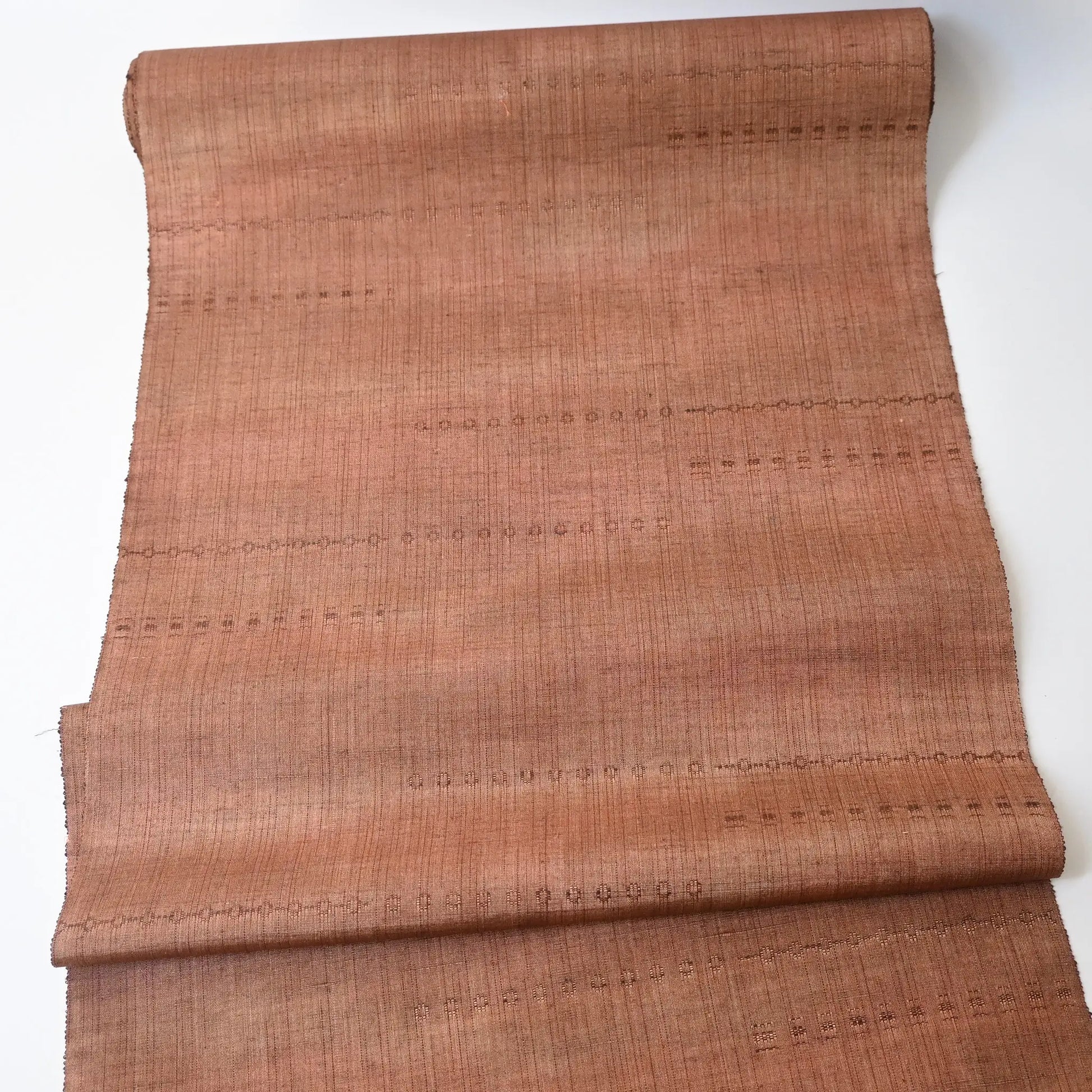 Full view of vintage pink brown tsumugi silk kimono fabric roll sold by the metre.