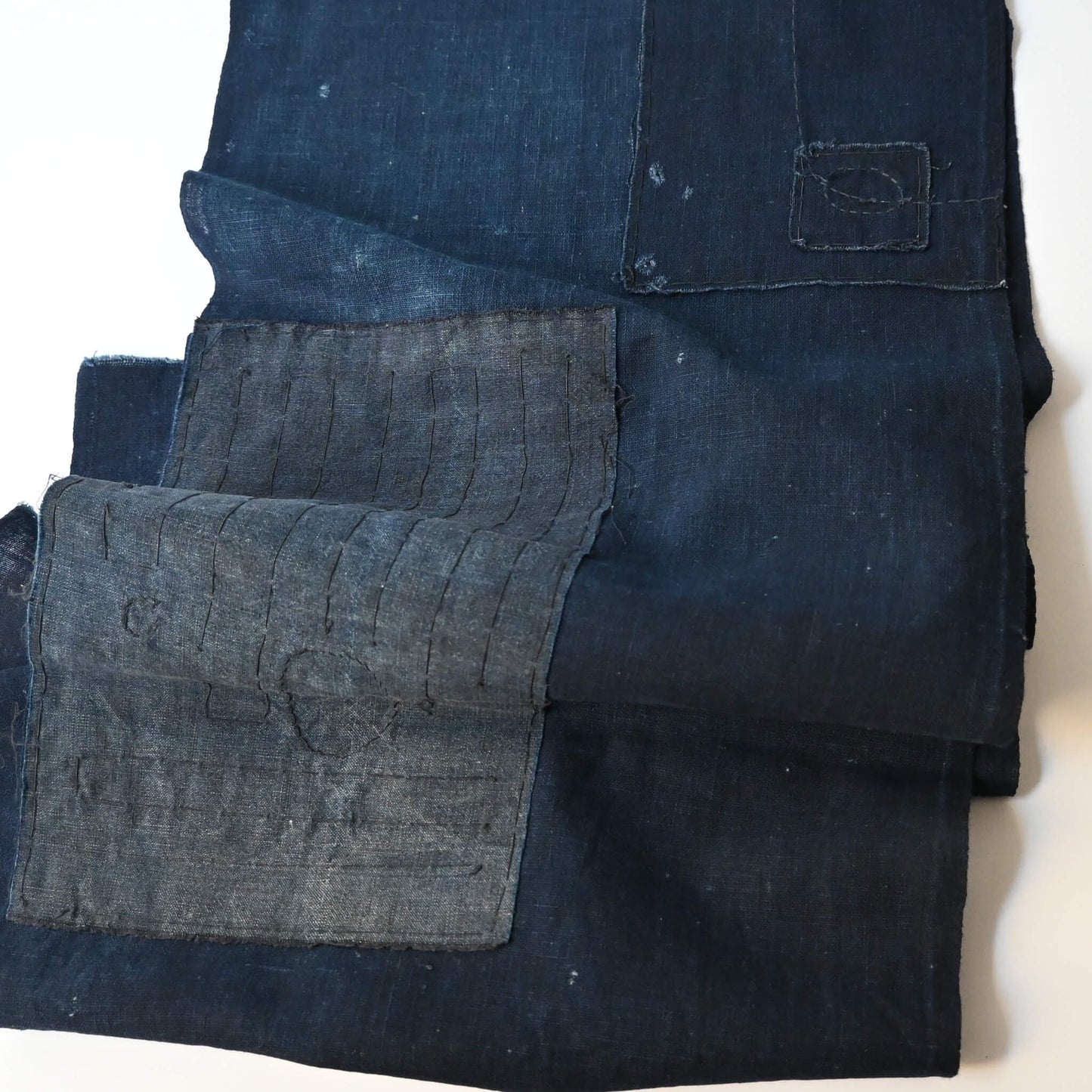 Detailed view of vintage Japanese plain deep  indigo cotton futon cover panel with patches.