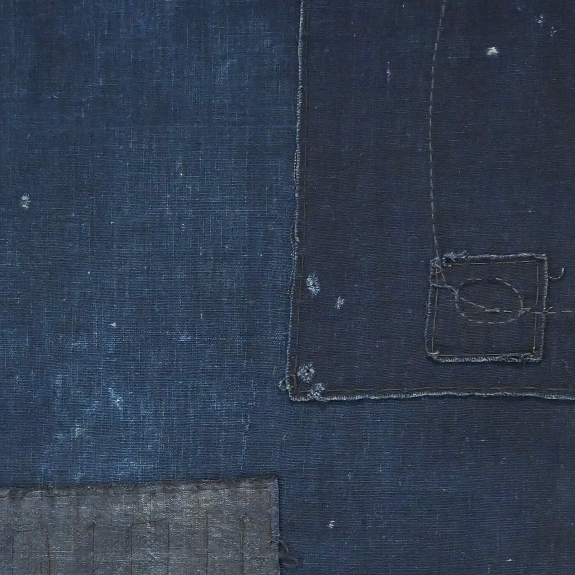 Detailed view of vintage Japanese plain deep  indigo cotton futon cover panel with patches.