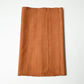Vintage plain tsumugi silk kimono fabric piece in warm ochre tone with slub texture.