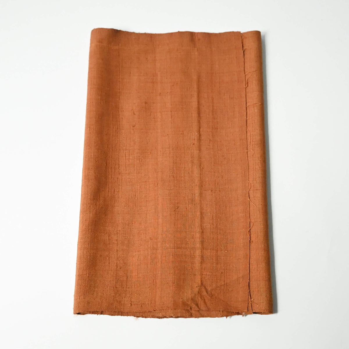 Vintage plain tsumugi silk kimono fabric piece in warm ochre tone with slub texture.