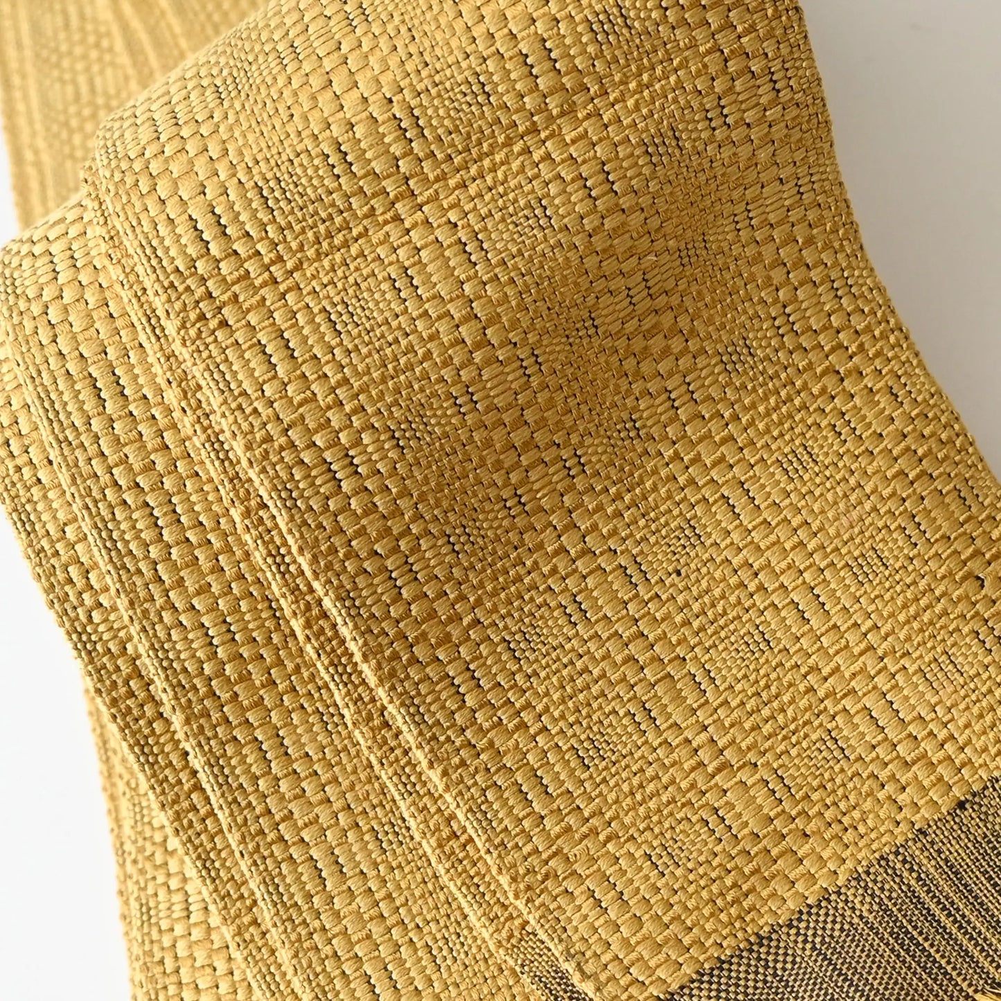 Close-up view of vintage Japanese men's silk Kaku Obi with woven design in soft yellow.
