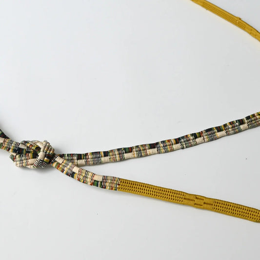 Detailed view of vintage recycled women's kimono dress accessories, silk Obijime cord in mustard yellow.