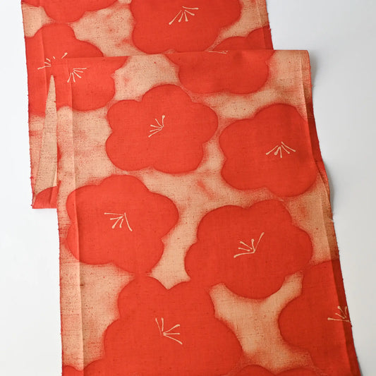 Full view of vintage Japanese tsumugi silk kimono fabric piece in reddish orange with bold plum blossom.