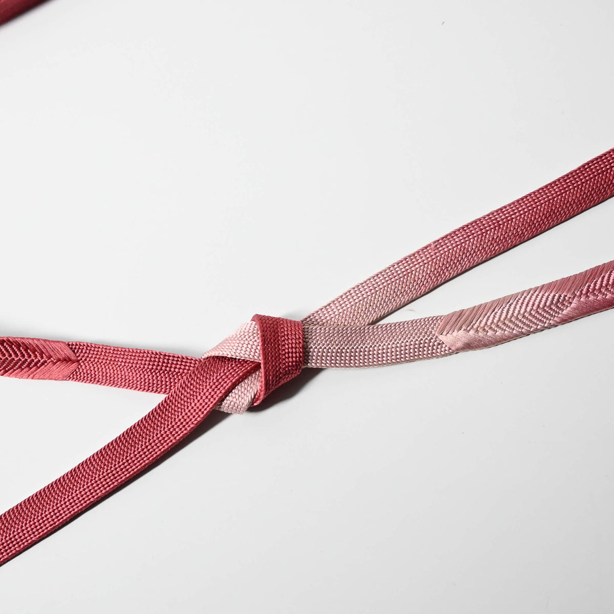 Detailed view of vintage rose pink silk obijime, kimono dress accessory, kumihimo cord.