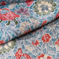 Close-up view of vintage silk crepe kimono fabric piece with Sarasa floral and bird patten in soft blue.
