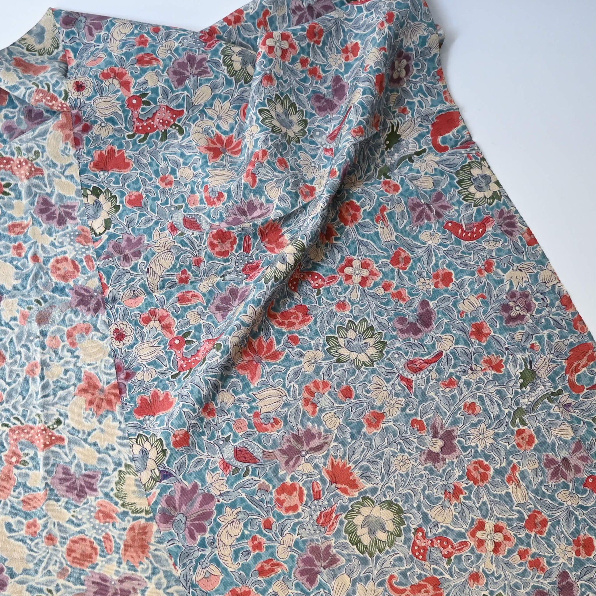 Vintage silk crepe kimono fabric piece with Sarasa floral and bird patten in soft blue.